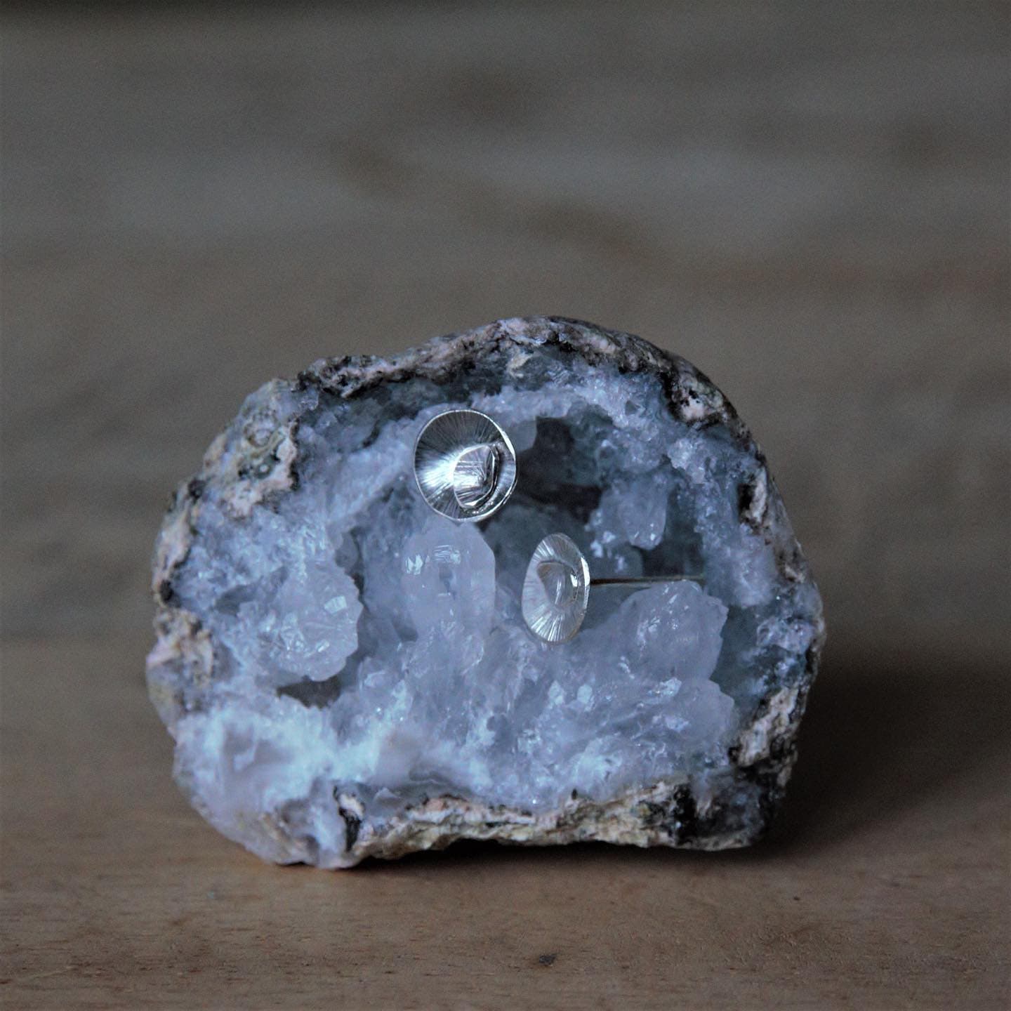 Zilveren oorbellen op ruwe kristal/geode