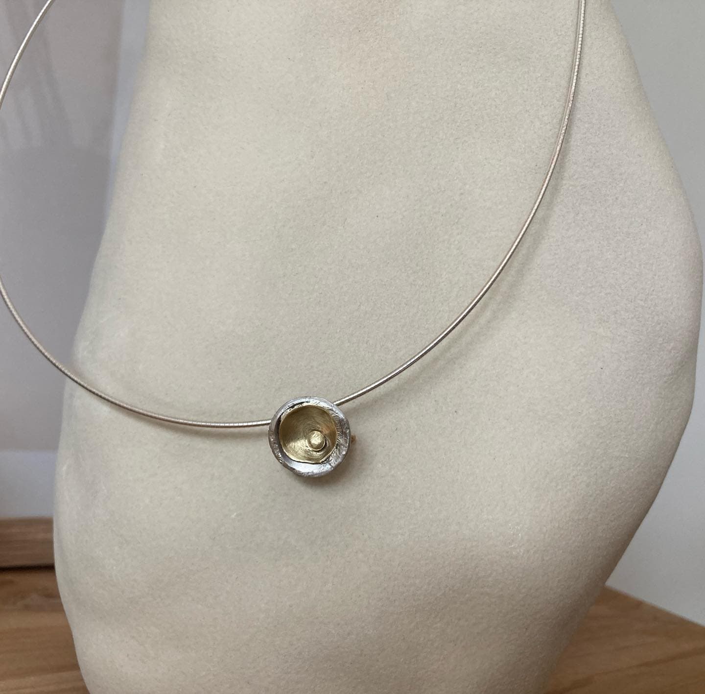Fijne halsketting met kleine hanger op tafel