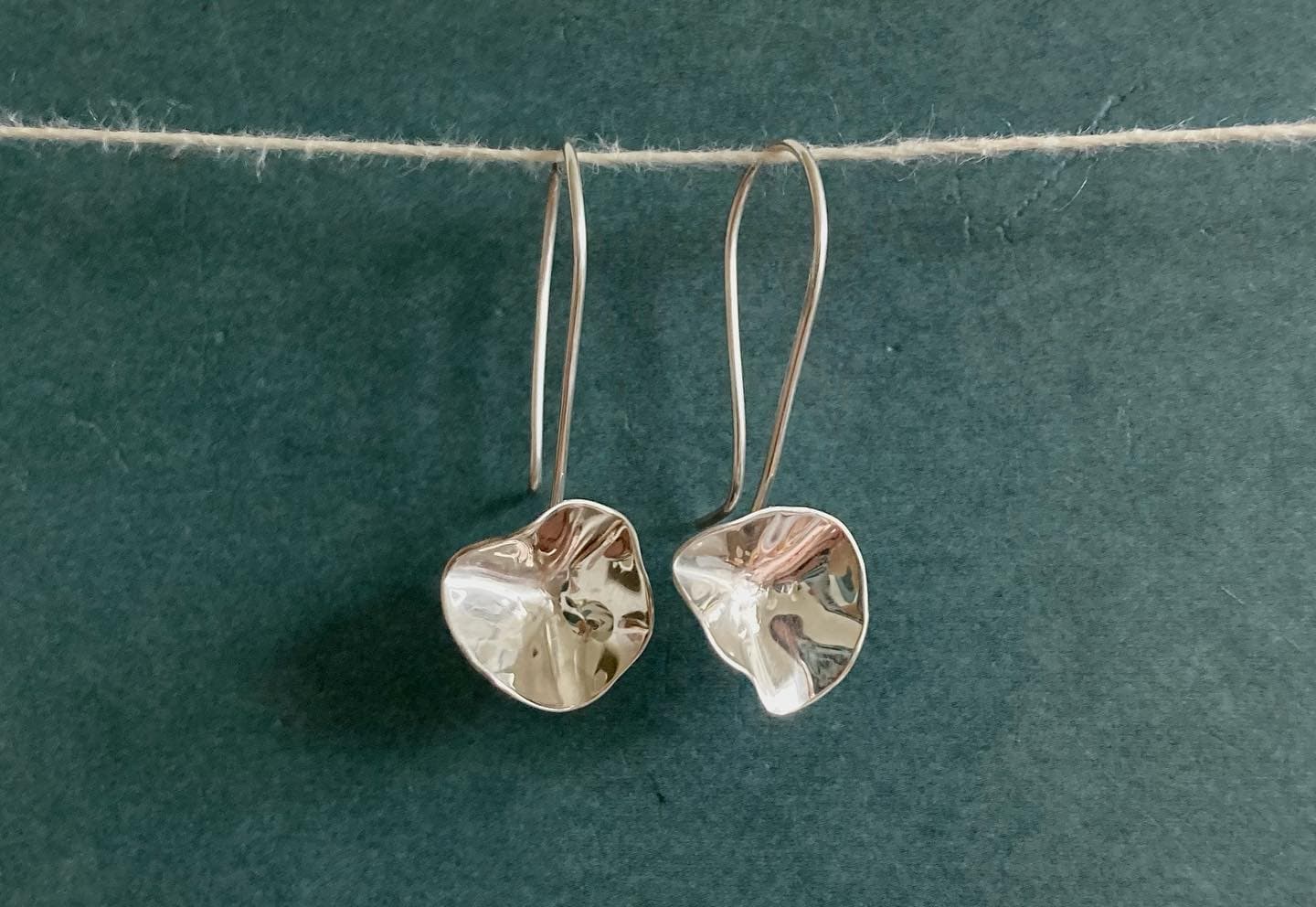 Grote gouden hanger-oorbellen op groene ondergrond