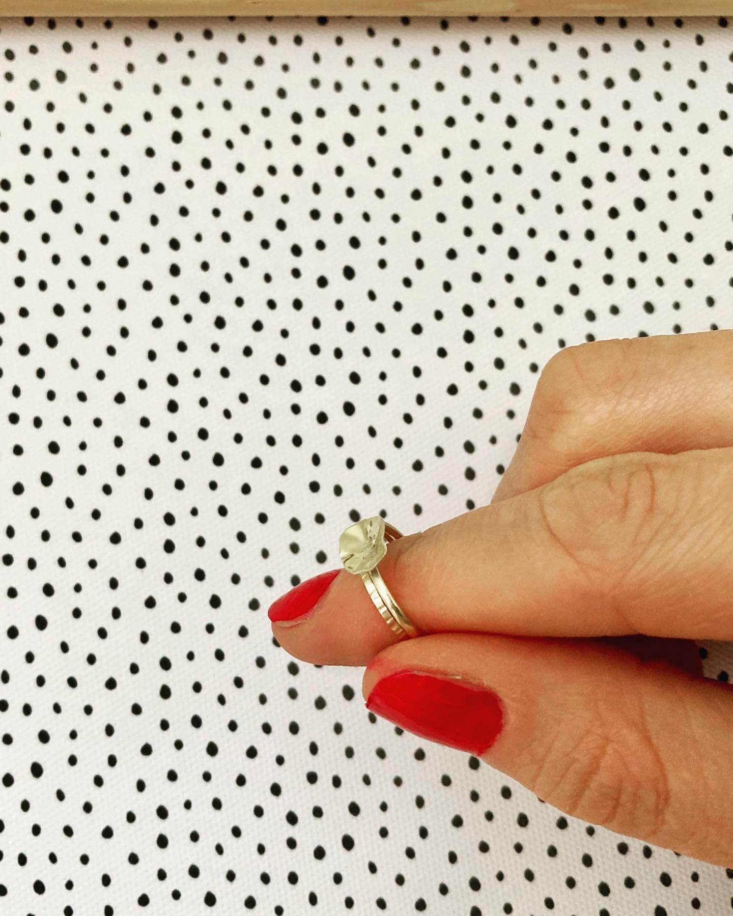 Hand met rode nagellak en gouden ring, close-up
