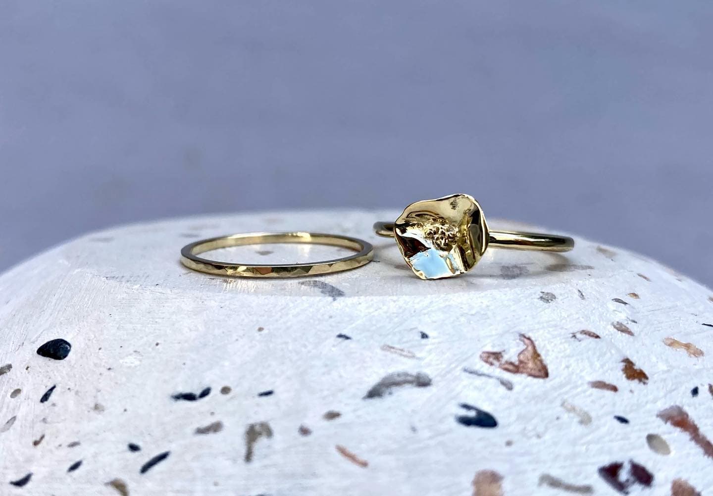 Gouden ring met klein steentje op terrazzo-ondergrond