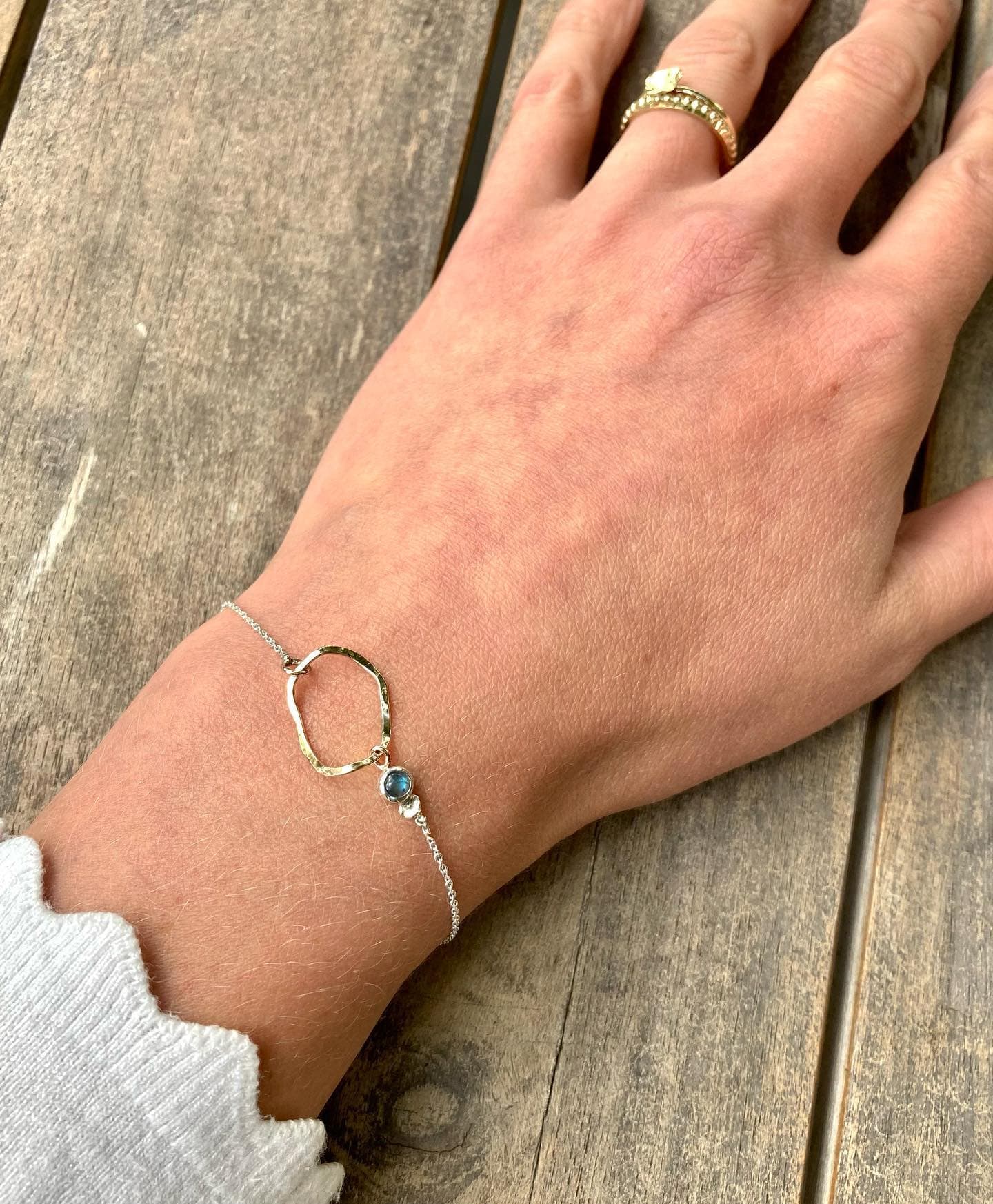 Fijne gouden armband op arm met trui