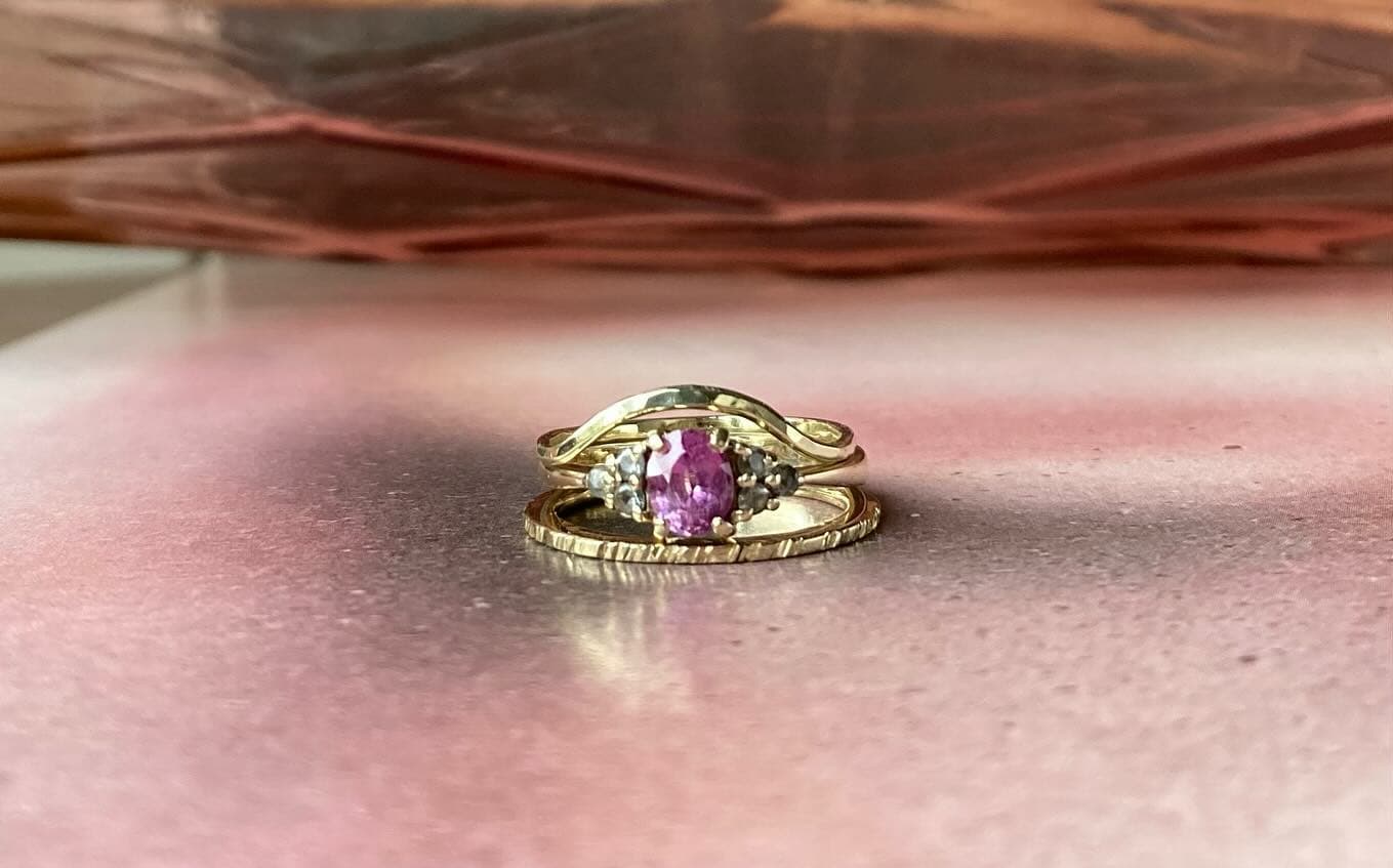 Gouden ring met gele facetsteen op perzikkleurige ondergrond