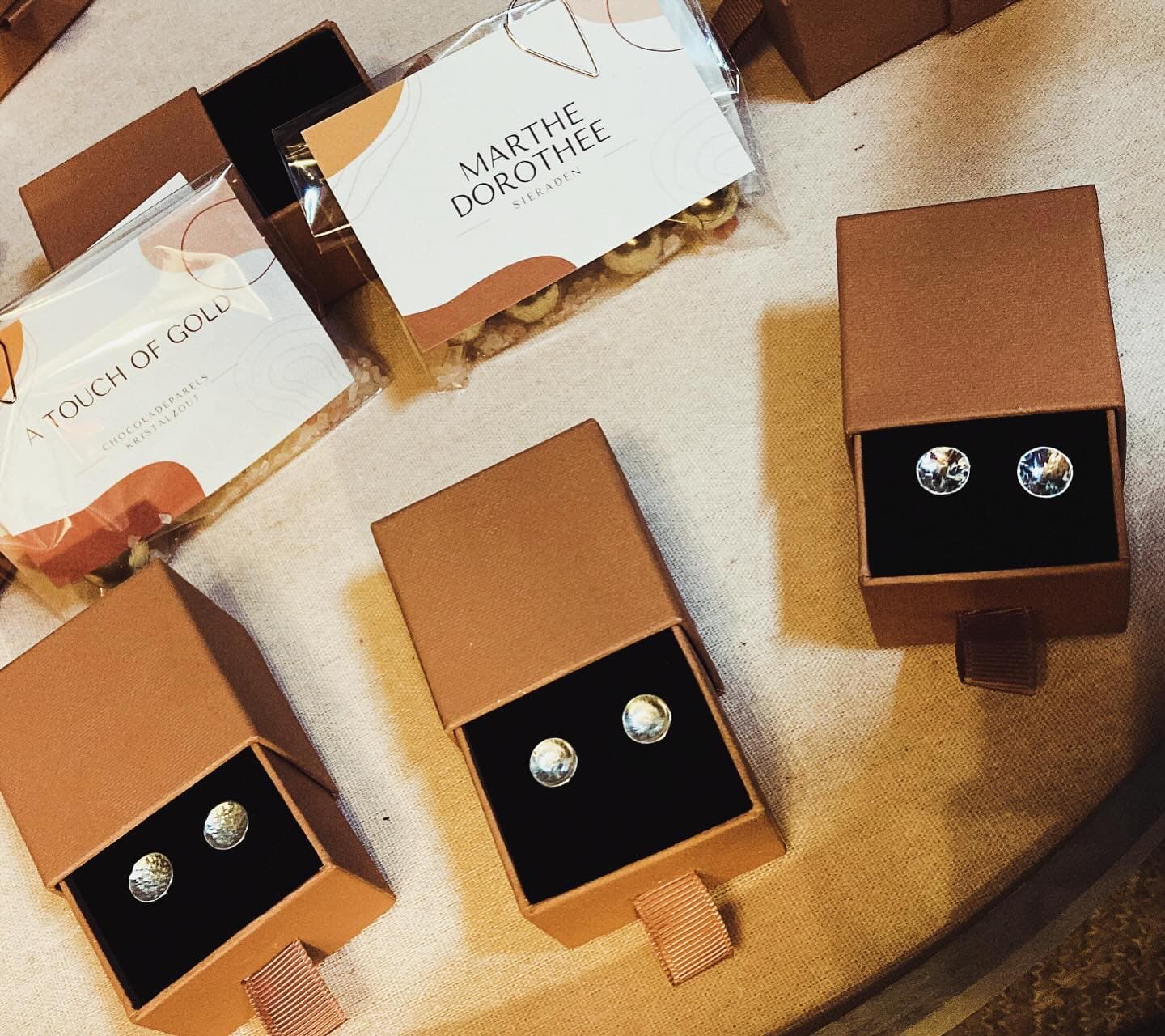 Verzameling oorbel-doosjes met sieraden naast elkaar