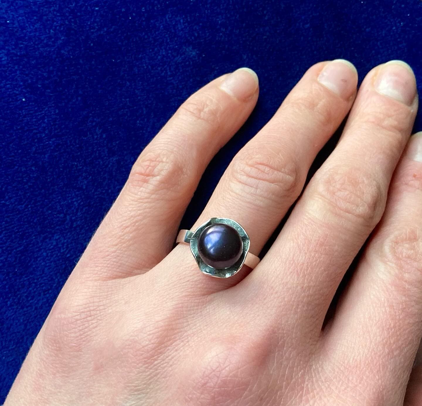 Gouden ring met grote donkerrode steen op vinger