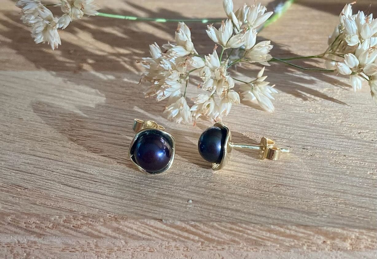 Paar oorbellen met donkerblauwe stenen in sieradendoosje