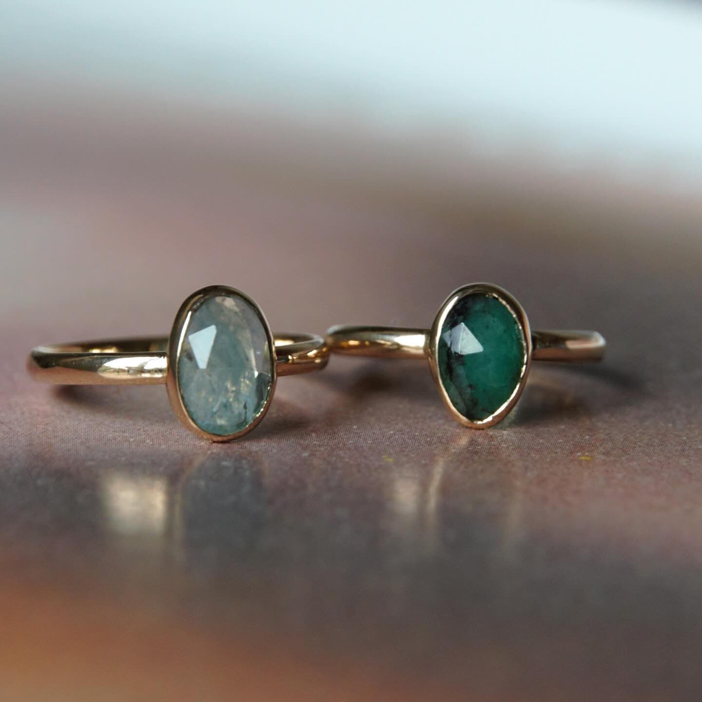 Gouden ring met groene facetsteen op tafel
