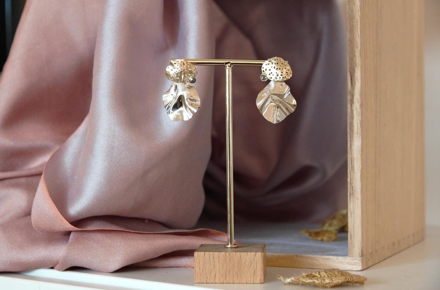 Oorbellen met bladvormige hangers op paarse stof