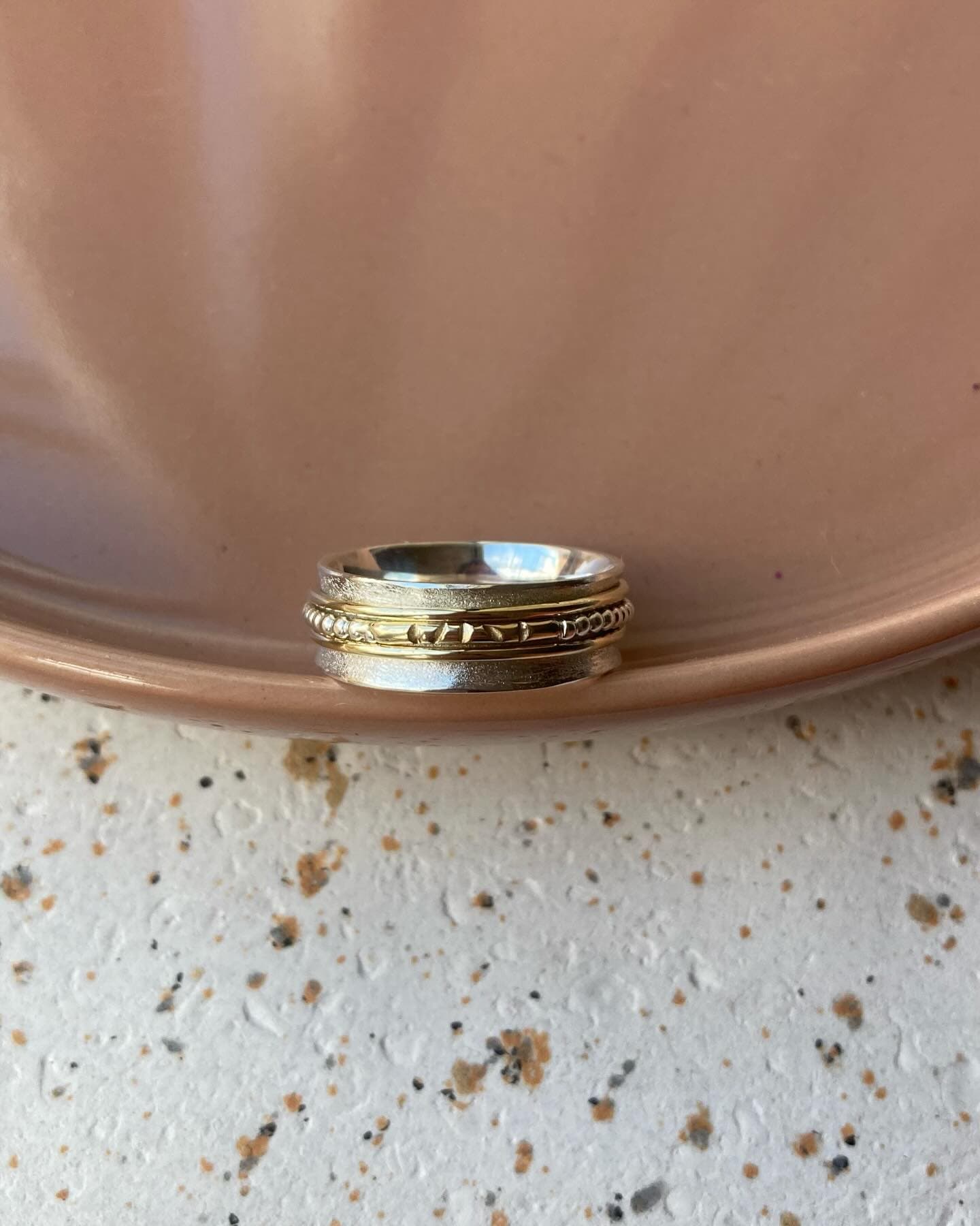Gouden ring met kleine diamant op wit-grijs terrazzo