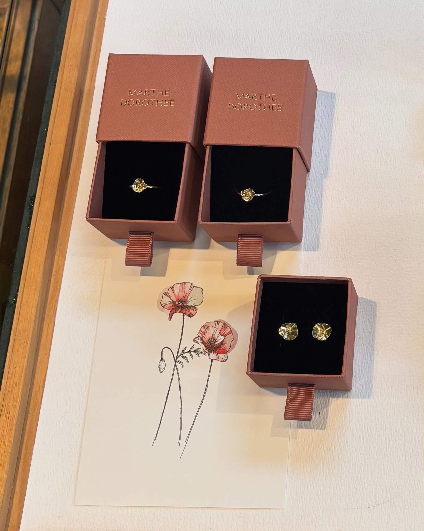 Oorbellen en ring gepresenteerd in nude-roze sieradendoosje