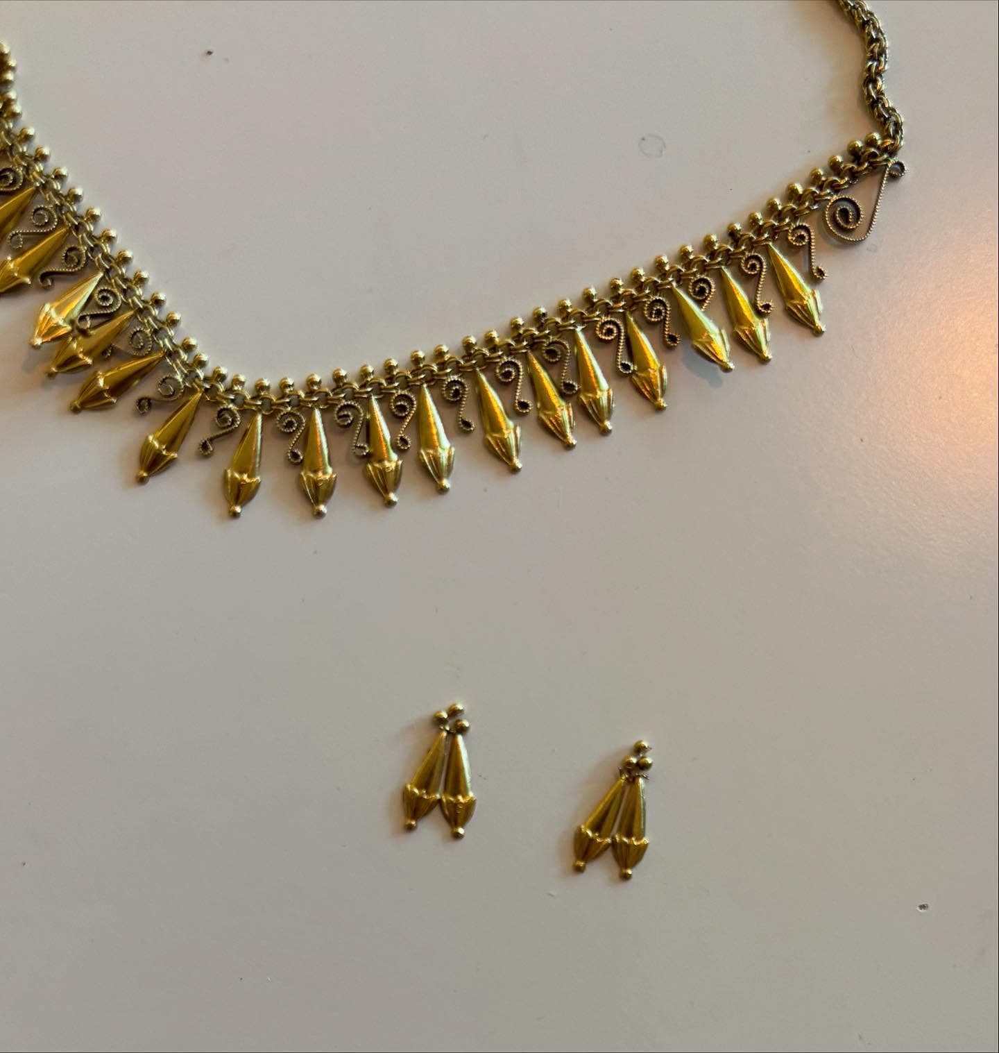 Collectie gouden oorbellen met fijne kraaltjes op witte ondergrond