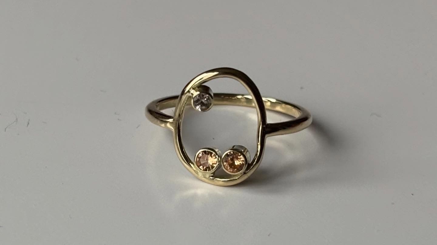Open gouden ring met twee kleine facetsteentjes, bovenaanzicht